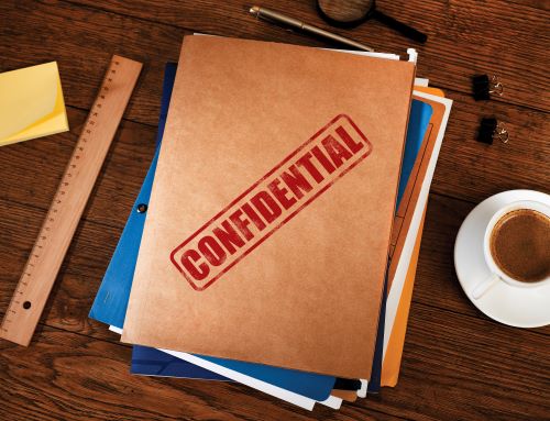 Stack of folders on desk with "Confidential" stamped on front.